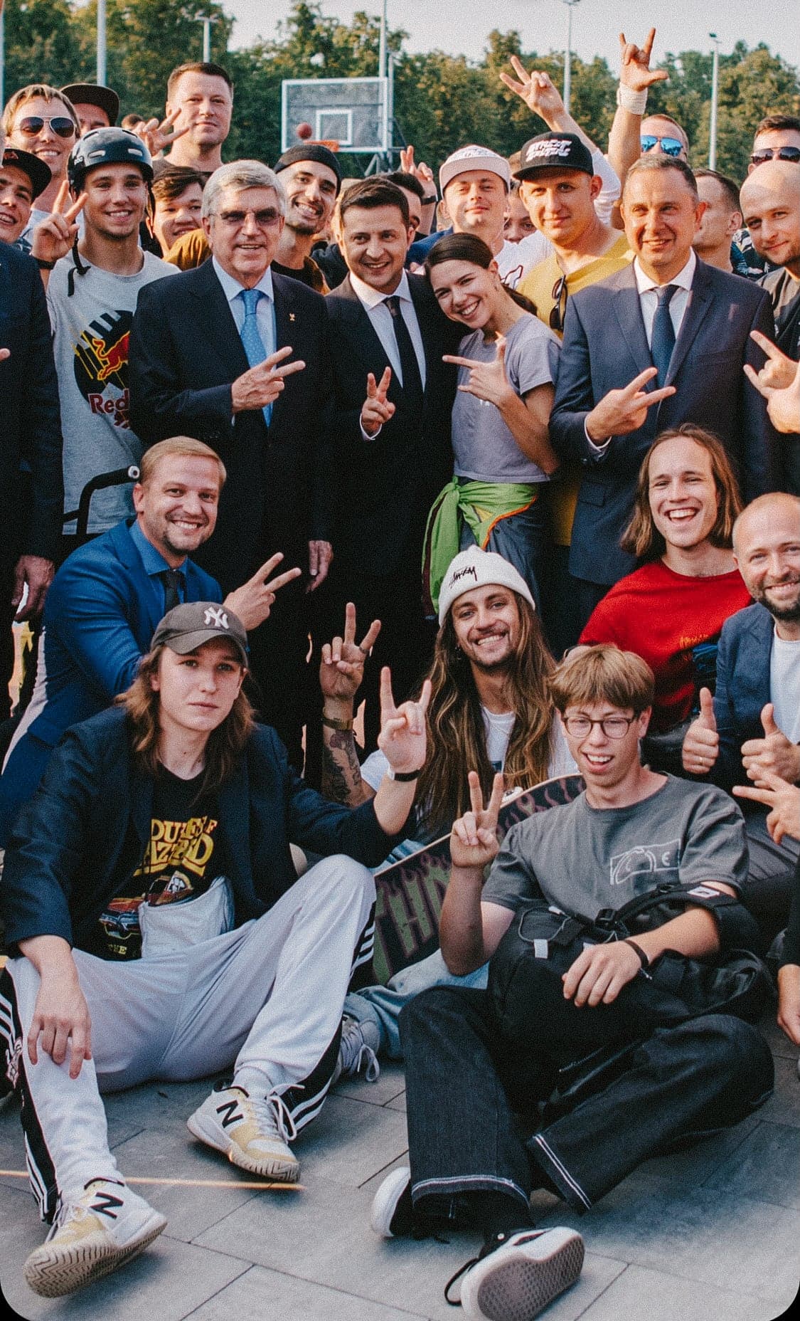 Group photo of skateboarders and officials at a skatepark opening